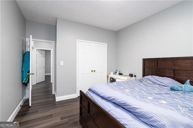 bedroom with a textured ceiling, a closet, and dark wood-type flooring