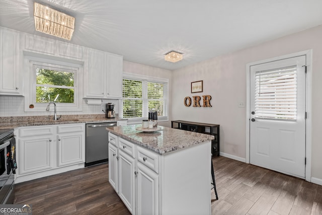 kitchen featuring a wealth of natural light, a kitchen island, appliances with stainless steel finishes, and white cabinets