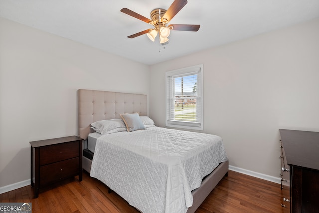 bedroom with dark hardwood / wood-style flooring and ceiling fan