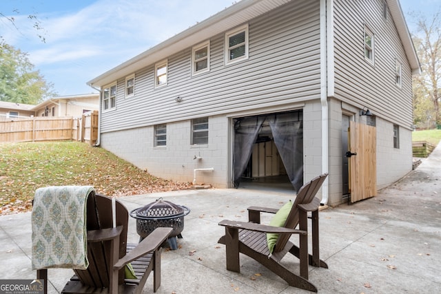 back of property featuring a patio and an outdoor fire pit