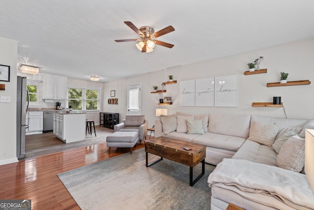 living room with ceiling fan and dark hardwood / wood-style flooring