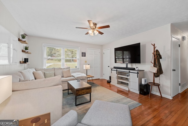 living room with light wood-type flooring and ceiling fan