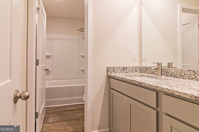 full bathroom with vanity, hardwood / wood-style floors, toilet, and tub / shower combination