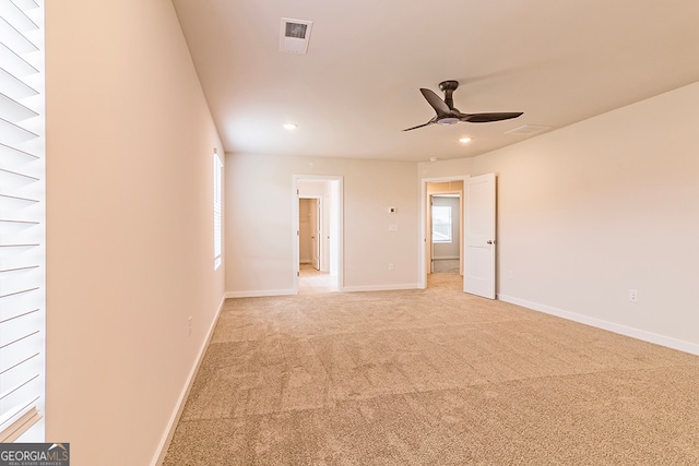 unfurnished room with light colored carpet and ceiling fan