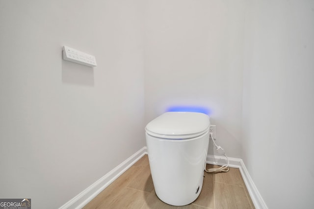 bathroom featuring wood-type flooring and toilet