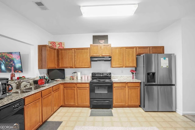 kitchen featuring black appliances, sink, and light stone countertops