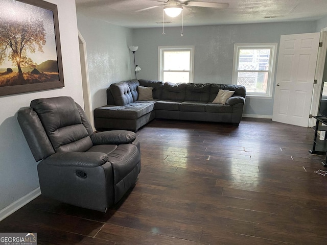 living room with a healthy amount of sunlight, ceiling fan, and dark wood-type flooring