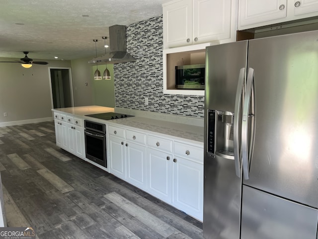 kitchen with dark wood-type flooring, white cabinets, wall chimney exhaust hood, appliances with stainless steel finishes, and ceiling fan