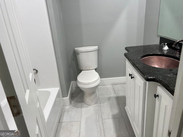 bathroom with a bath, vanity, and toilet