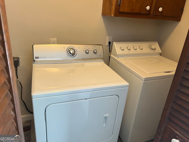 laundry room with separate washer and dryer and cabinets