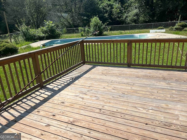 deck with a swimming pool and a yard