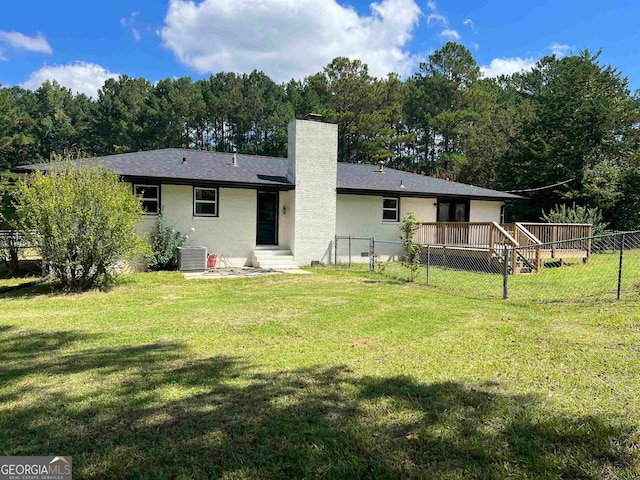 rear view of house featuring cooling unit, a deck, and a yard