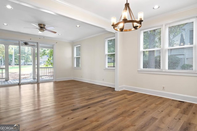 empty room with ceiling fan with notable chandelier, ornamental molding, and dark hardwood / wood-style flooring