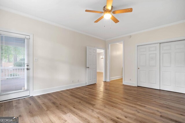 unfurnished bedroom featuring ceiling fan, hardwood / wood-style flooring, a closet, and ornamental molding