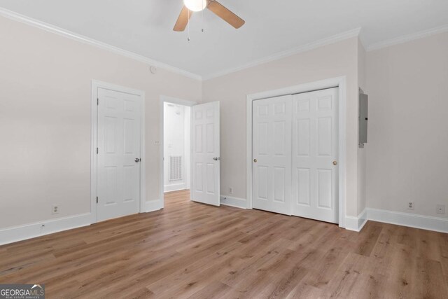 unfurnished bedroom with ornamental molding, electric panel, ceiling fan, and light hardwood / wood-style flooring