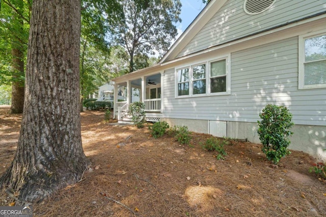 view of side of property with ceiling fan and a porch