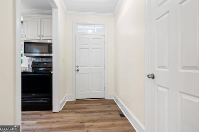 foyer with light hardwood / wood-style flooring and crown molding