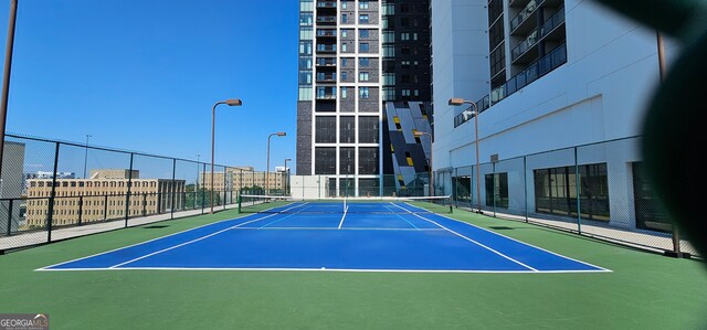 view of tennis court featuring basketball hoop