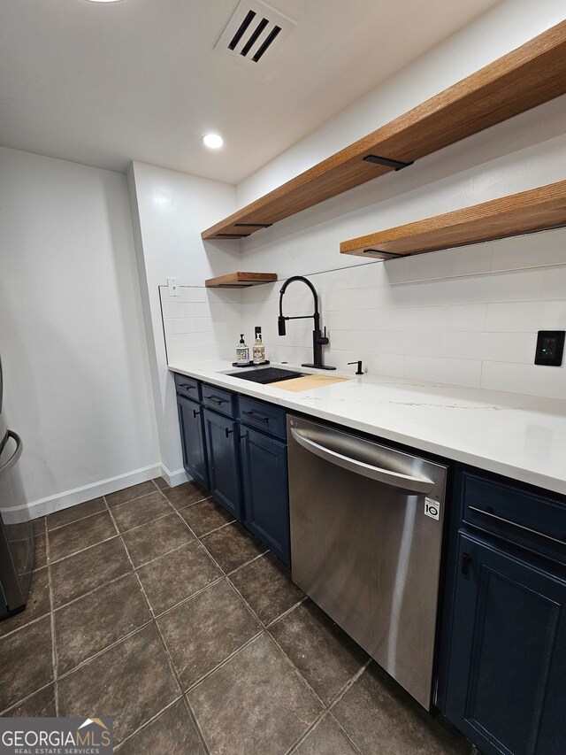 kitchen featuring dark tile patterned flooring, dishwasher, tasteful backsplash, sink, and blue cabinets