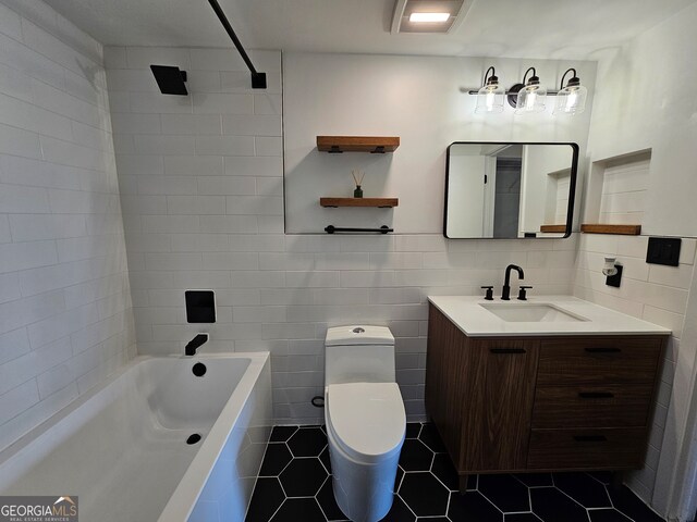 full bathroom with tile walls, bathing tub / shower combination, vanity, tile patterned flooring, and toilet