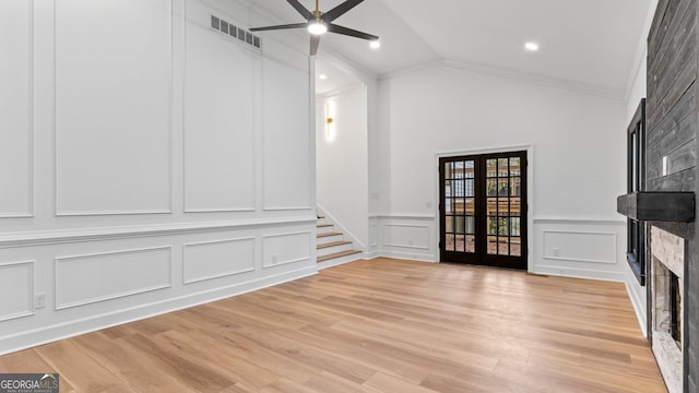 unfurnished living room featuring ceiling fan, lofted ceiling, french doors, light hardwood / wood-style flooring, and a fireplace