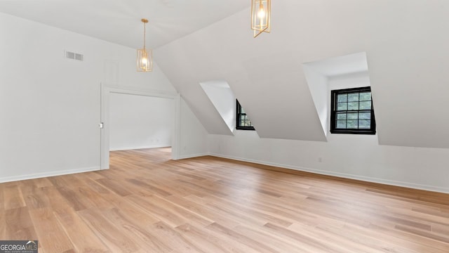 additional living space with light wood-type flooring and lofted ceiling