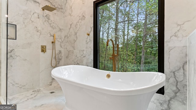 bathroom with shower with separate bathtub and tile walls