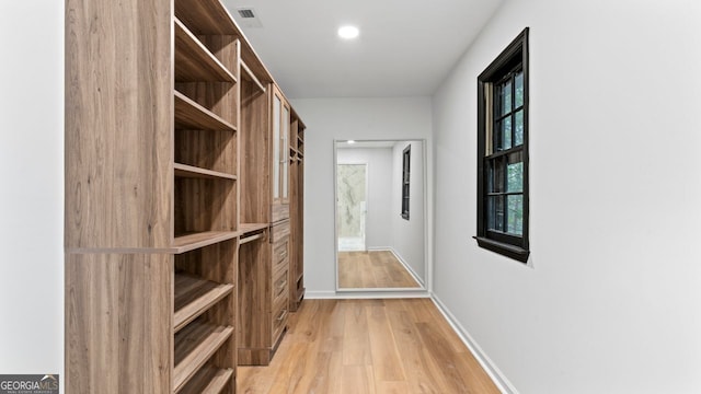 walk in closet with light wood-type flooring