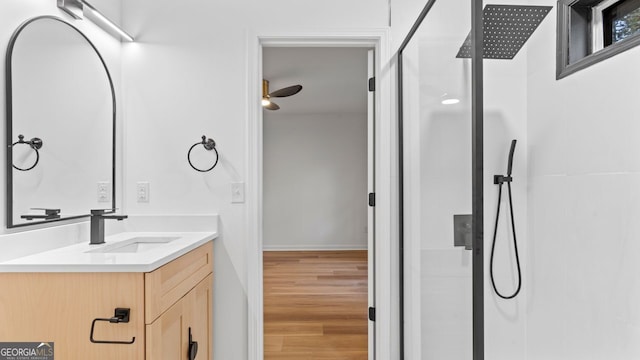 bathroom featuring hardwood / wood-style floors, ceiling fan, a shower, and vanity