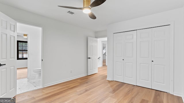 unfurnished bedroom with a closet, light hardwood / wood-style floors, ceiling fan, and connected bathroom