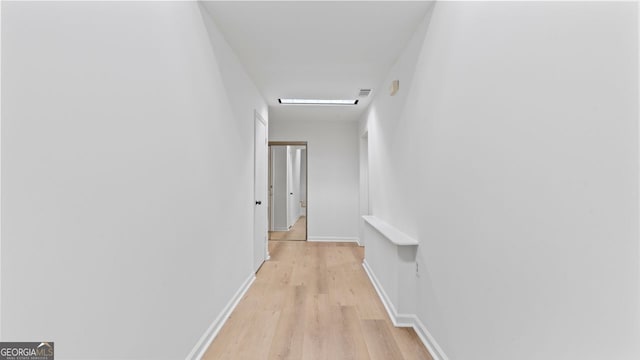 hallway with light hardwood / wood-style floors