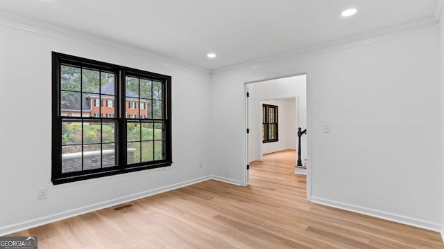 spare room featuring light hardwood / wood-style flooring and ornamental molding