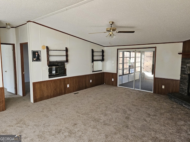 unfurnished living room with a textured ceiling, a stone fireplace, and ceiling fan