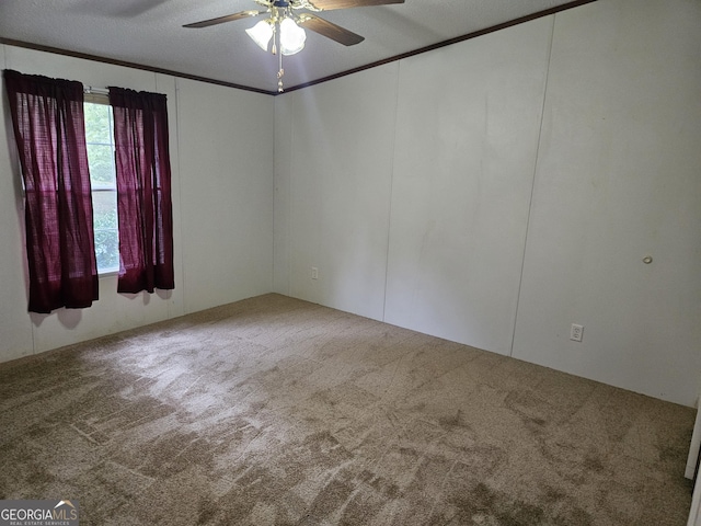 carpeted spare room with ceiling fan, ornamental molding, and a textured ceiling