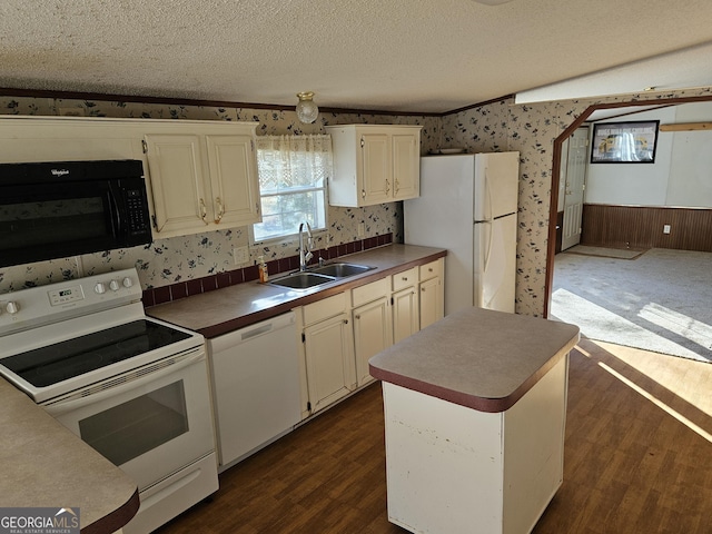 kitchen featuring sink, a center island, dark wood-type flooring, a textured ceiling, and white appliances