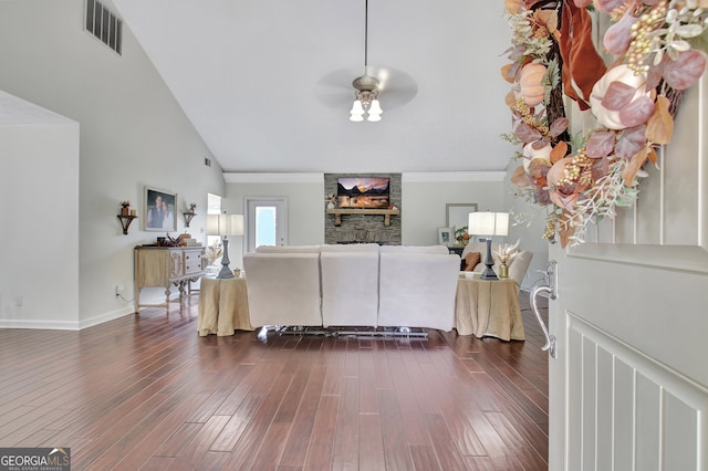 living room featuring dark hardwood / wood-style flooring, crown molding, high vaulted ceiling, a stone fireplace, and ceiling fan