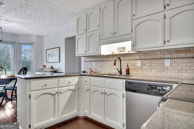 kitchen featuring sink, kitchen peninsula, and white cabinetry