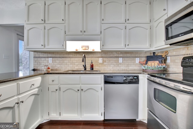 kitchen featuring white cabinetry, backsplash, stainless steel appliances, dark hardwood / wood-style floors, and sink