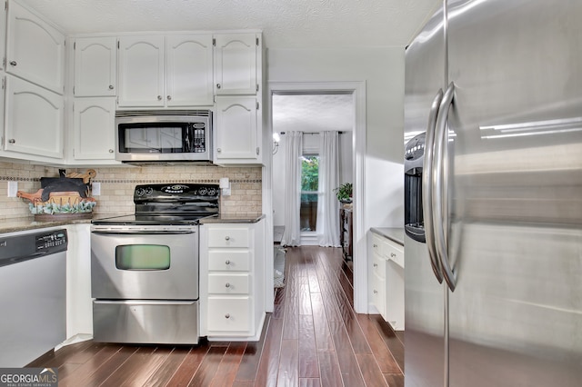 kitchen with stainless steel appliances, white cabinets, and dark wood-type flooring