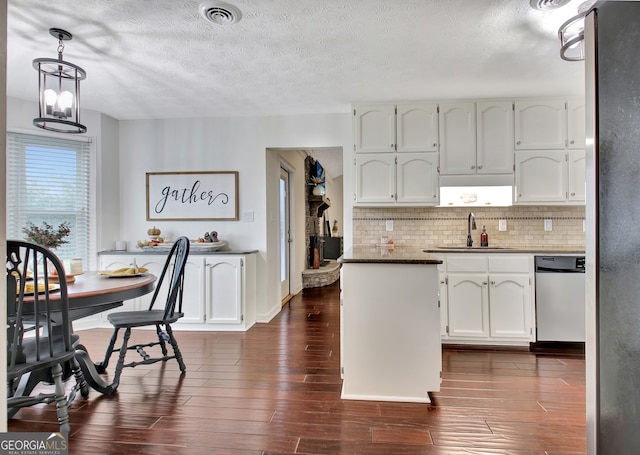 kitchen featuring white cabinetry, dishwasher, pendant lighting, and dark hardwood / wood-style flooring