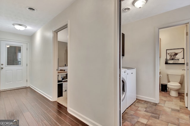 interior space featuring cabinets, hardwood / wood-style floors, a textured ceiling, and separate washer and dryer