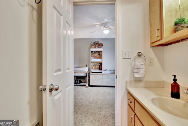 bathroom featuring a textured ceiling, vanity, and ceiling fan