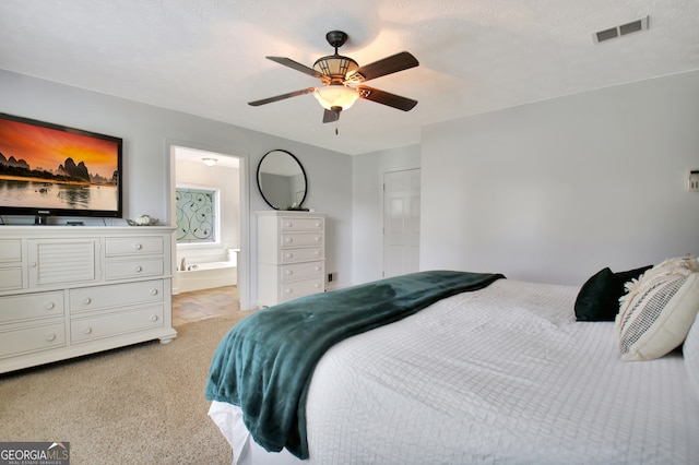 carpeted bedroom with connected bathroom, ceiling fan, and a textured ceiling