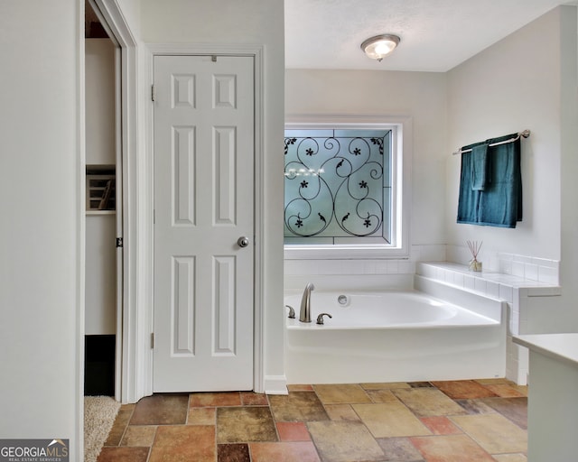 bathroom with vanity and a tub to relax in