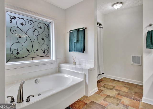 bathroom with a textured ceiling and shower with separate bathtub