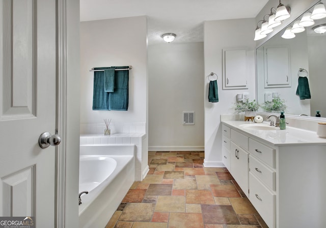 bathroom featuring vanity and a washtub