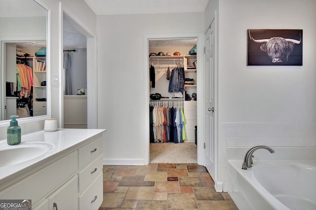 bathroom featuring a tub to relax in and vanity