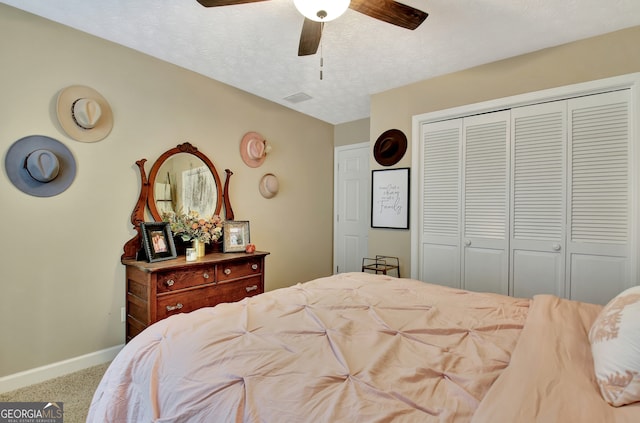 bedroom with a closet, ceiling fan, carpet floors, and a textured ceiling