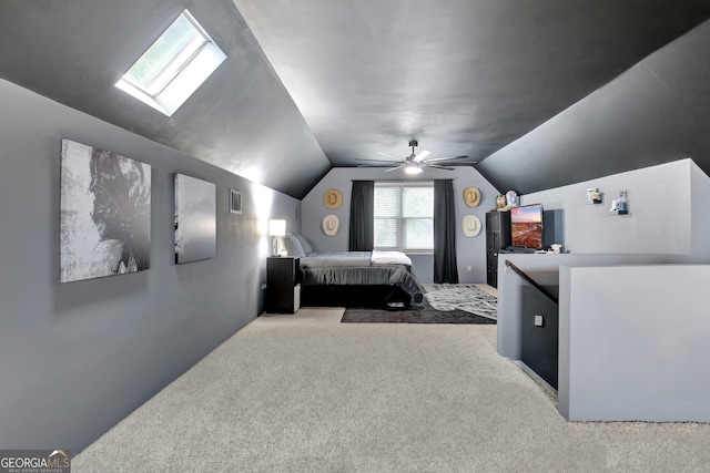 carpeted bedroom with vaulted ceiling with skylight and ceiling fan