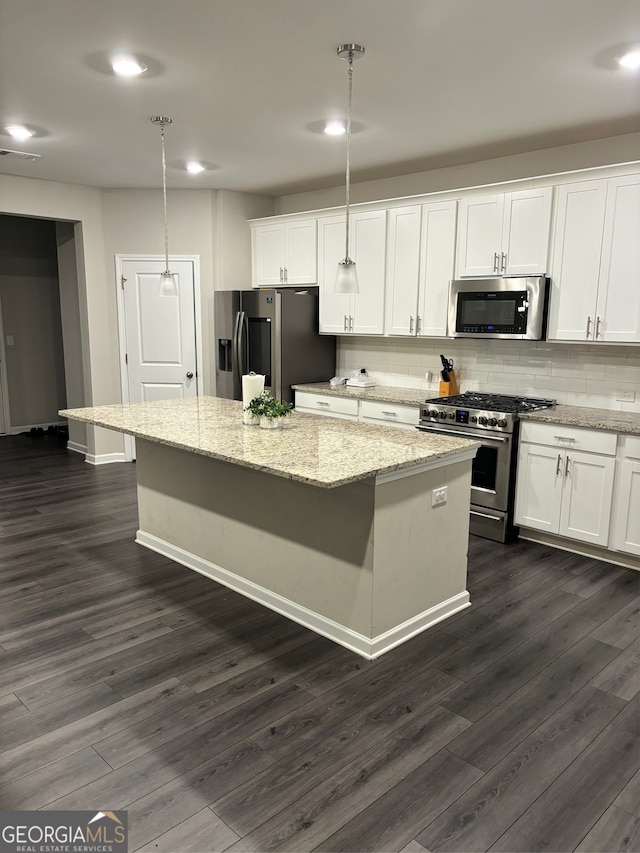 kitchen with a center island, pendant lighting, stainless steel appliances, and white cabinets